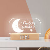 Lámpara LED personalizada en forma de medio óvalo con luna sonriente y estrellitas en su interior, brindando una iluminación suave y encantadora